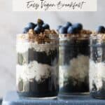 Pinterest Pin Image of a 3 mason jars with layers of a high protein smoothis and overnight oats topped with fresh granola and blueberries. The image is to show what the final recipes should look like. Text overlay reads High Protien Overnight Oats Parfait. Busy mom and Picky Eater Approved.