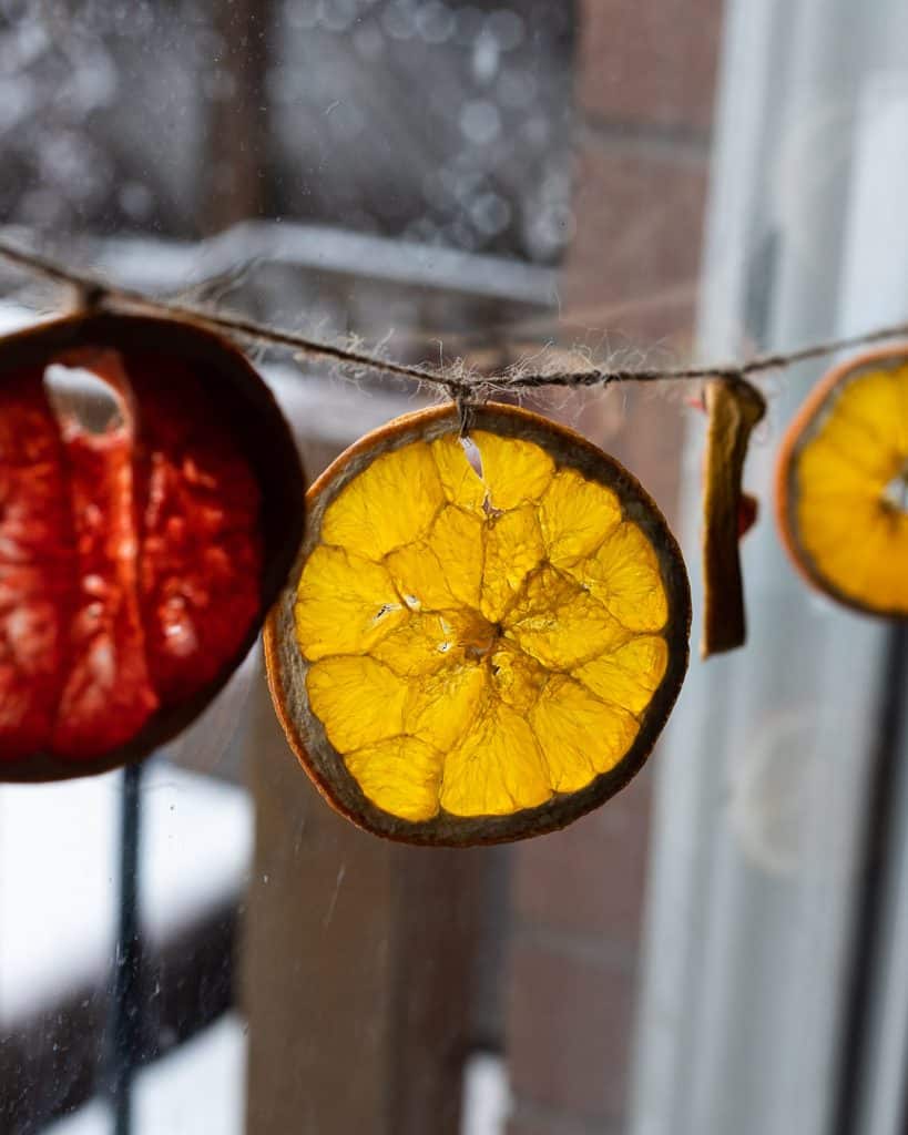Dried oranges strung up as garlands by a window