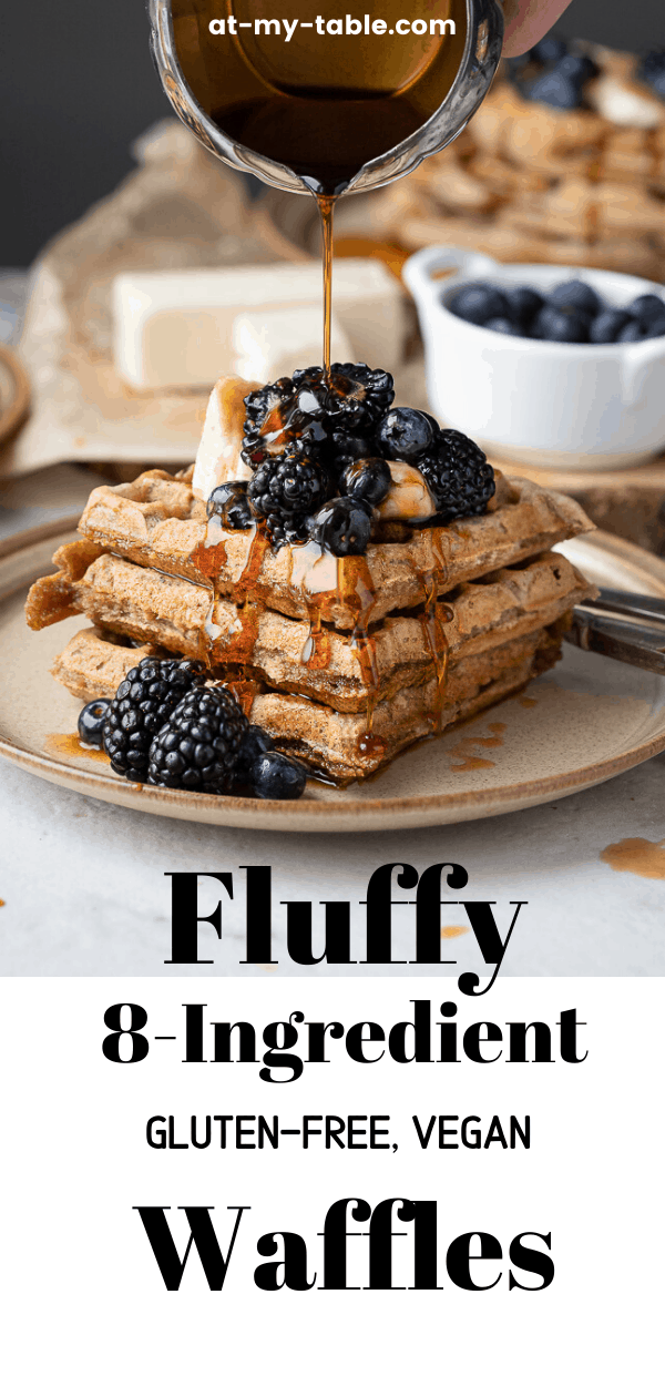 Stack of gluten free waffles with berries on top being drizzled with maple syrup
