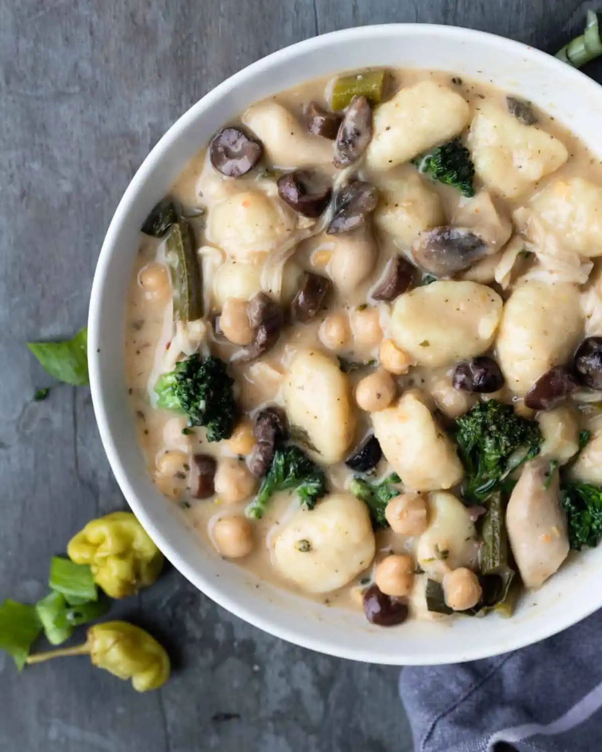 Delicious vegan gnocchi dish served in a bowl, featuring a creamy sauce, broccolini, mushrooms, and chickpeas