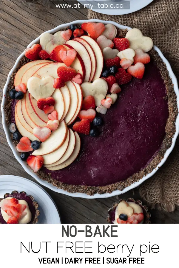 bird eye view of a no bake berry pie recipe topped with fresh apples and strawberries on a wooden table