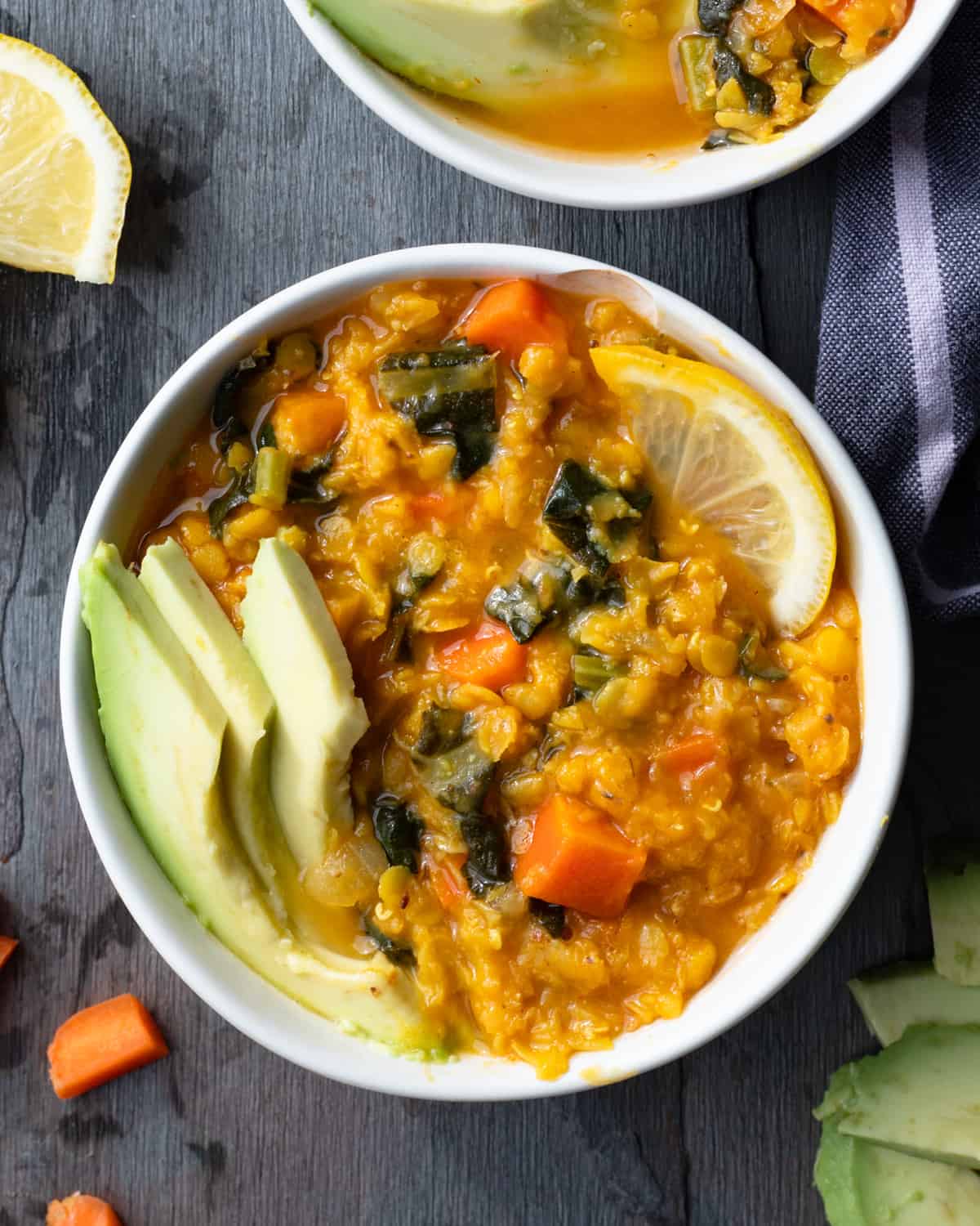 Image of two bowls of lemony lentil keto-friendly stew. This stew is made with carrots, kale and red lentils in the instant pot. The bowls are sitting on a table