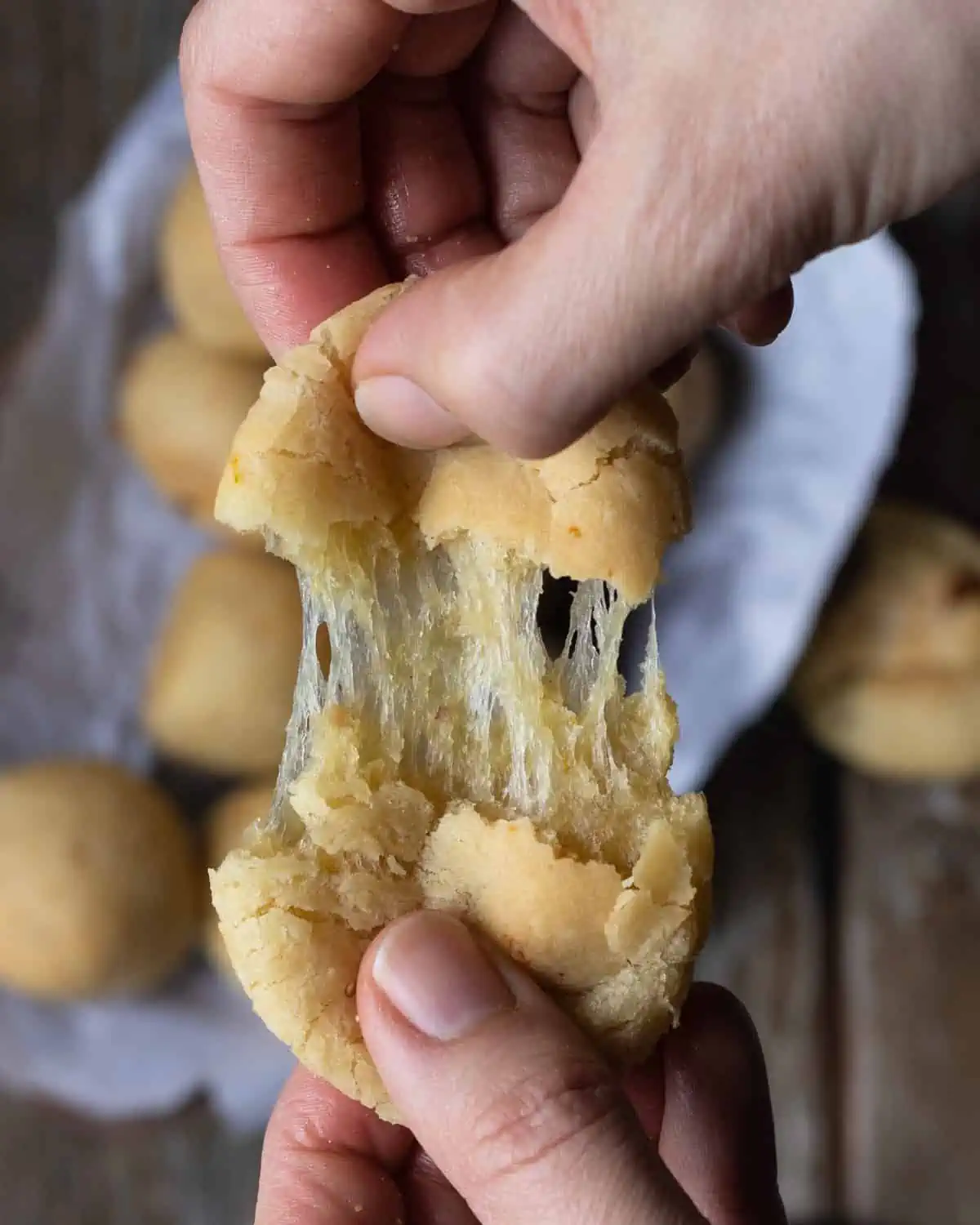 Vegan, gluten free Brazilian cheese breads being stretched out 