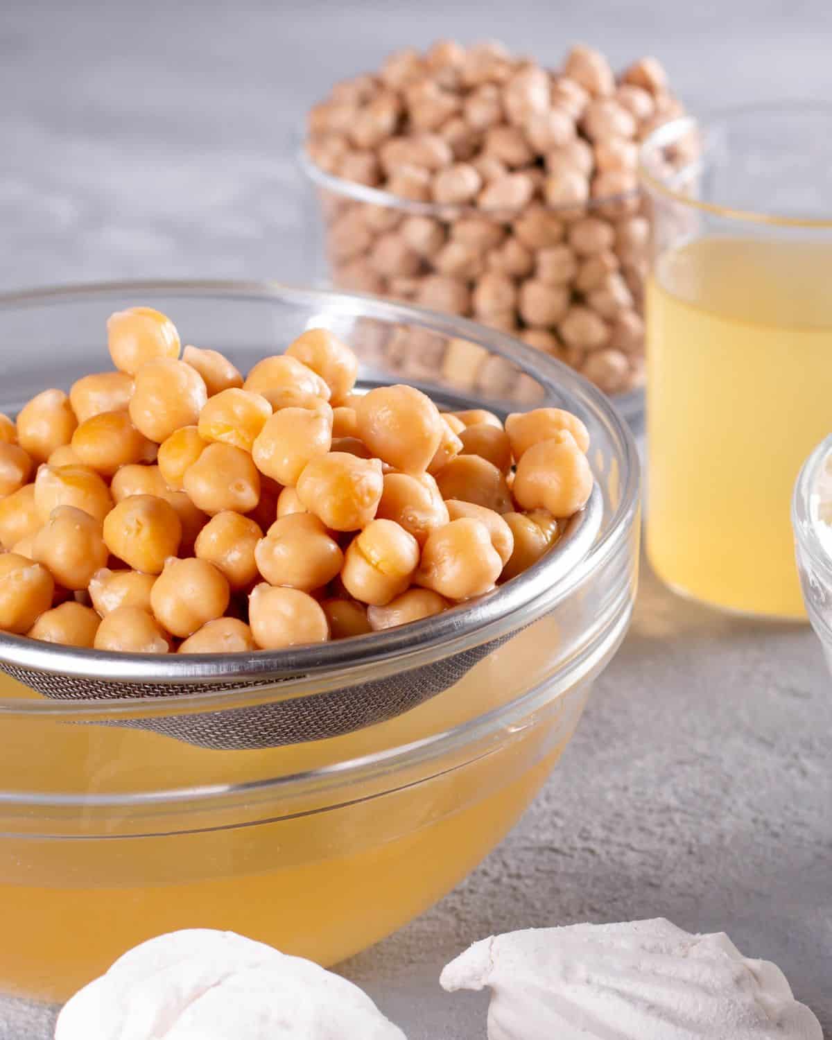 Image of chickpeas and chickpea liquid. The image is for a recipe post on how to use chickpea liquid or aquafaba in place of eggs.