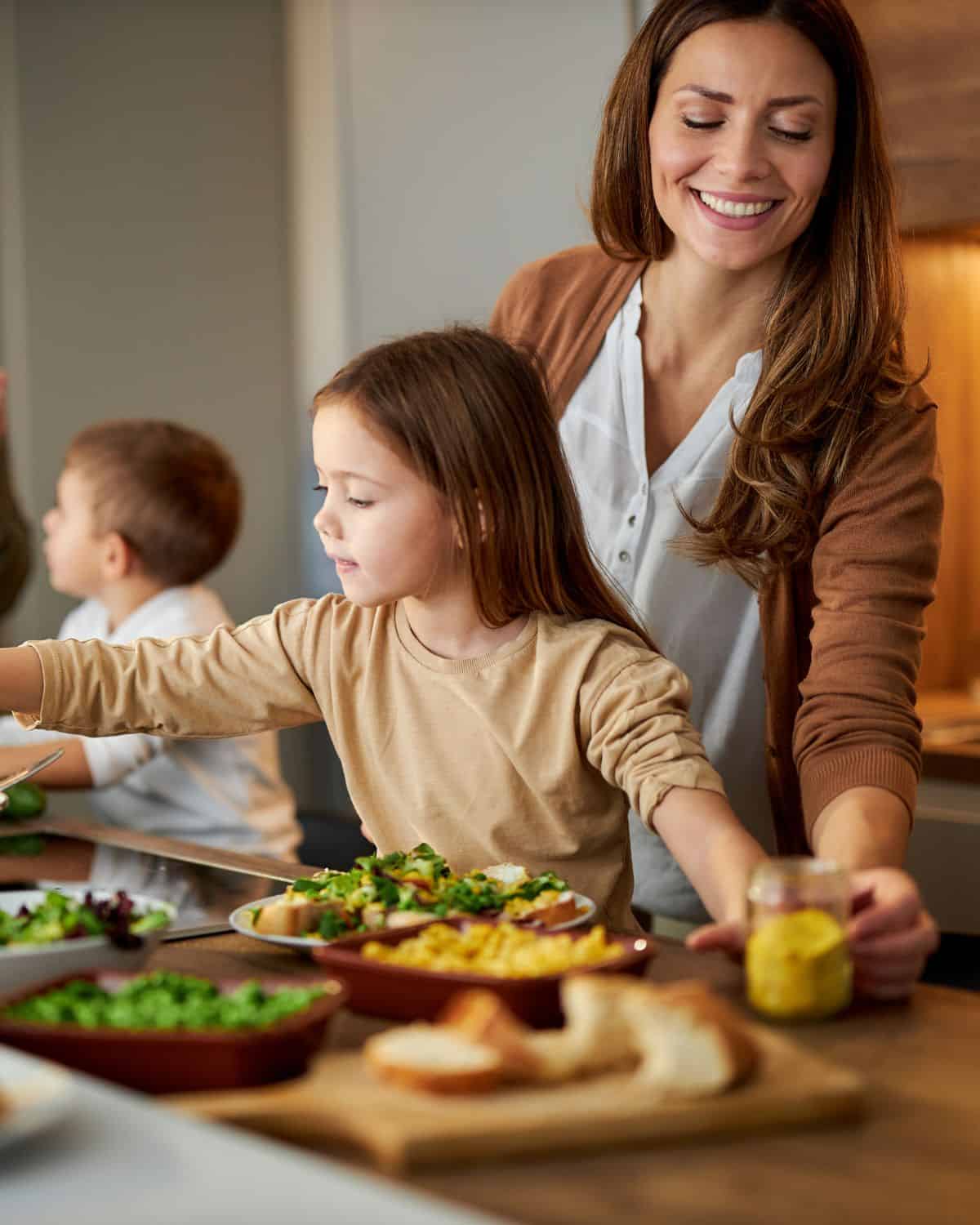 Image of a mom cooking with her daughter to creat balanced vegan meals.