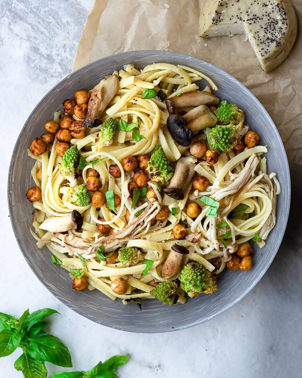 Bowl filled with delicious sheet pan vegan alfredo pasta, featuring roasted mushrooms, chickpeas, and romanesco cauliflower, topped with creamy vegan alfredo sauce.