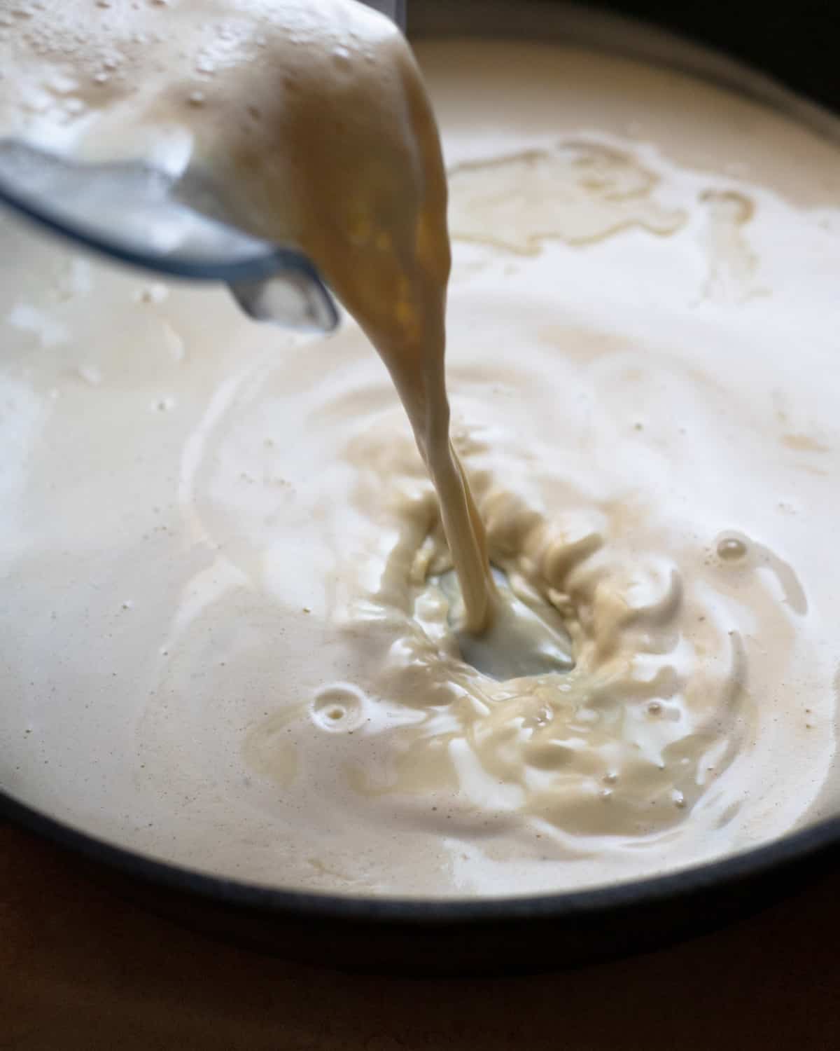 Close up image of a vegan cheese sauce being made in a cast iron.