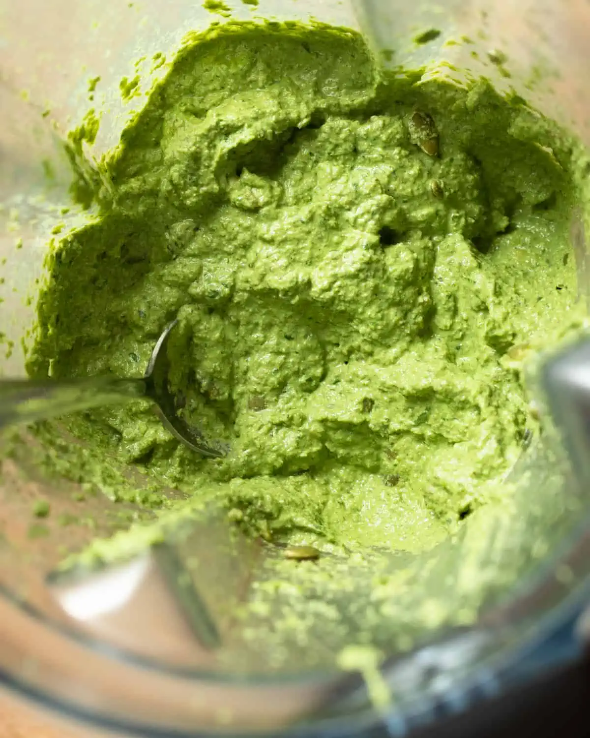 Image of vegan nut-free pesto sauce in a vitamix to show the texture of the sauce for a recipe post