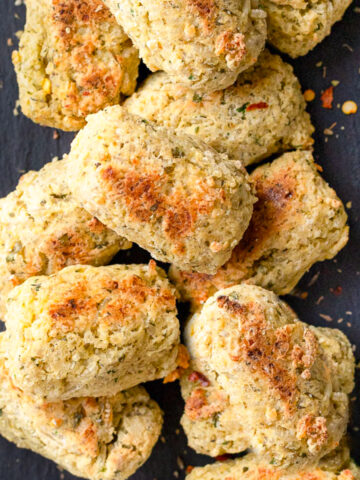 Stack of baked rice balls on a plate showing thier cripsy texture and golden brown color.