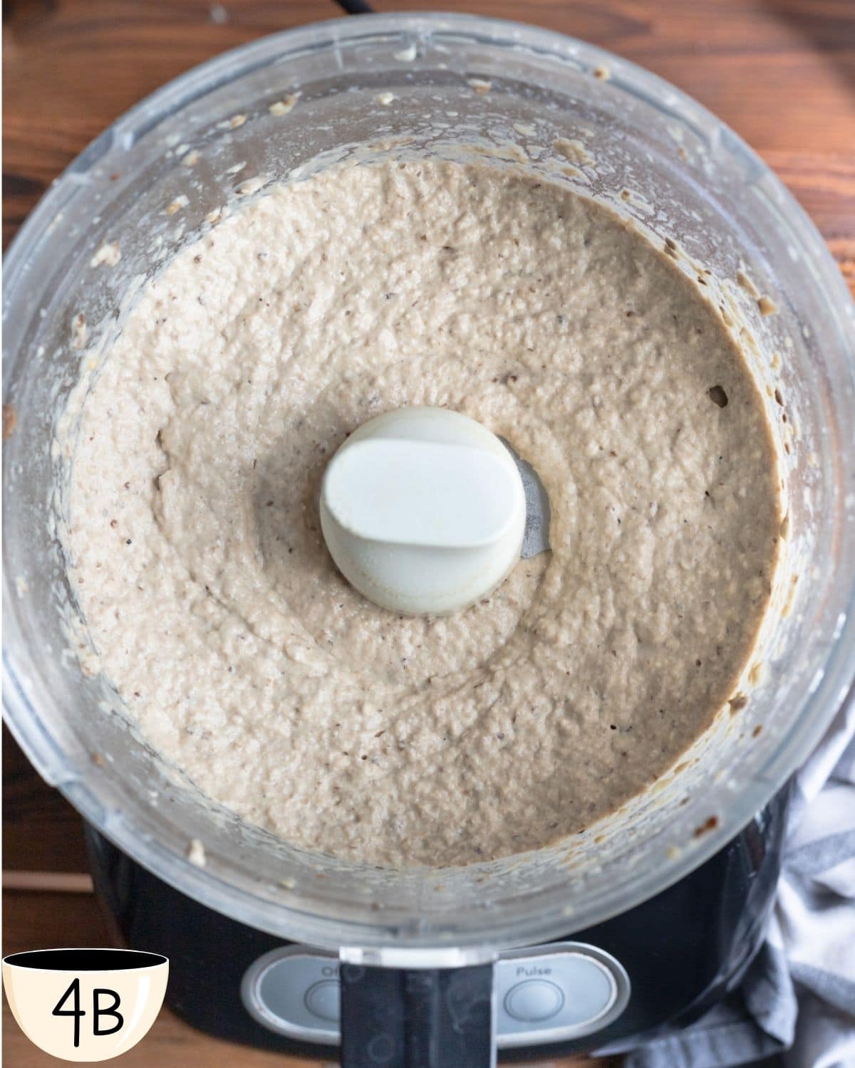 A food processor with a creamy blended eggplant dip recipe ready to be eaten.