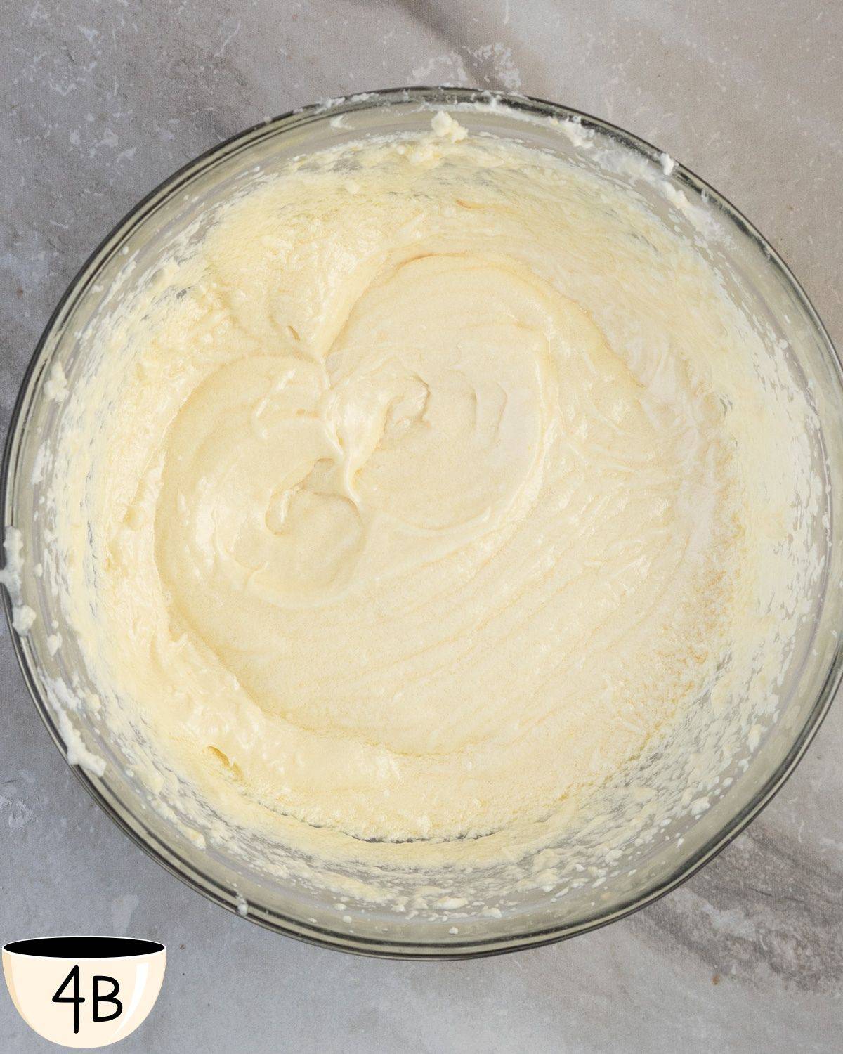 A smooth and homogeneous muffin batter in a glass bowl, ready for the addition of dry ingredients.