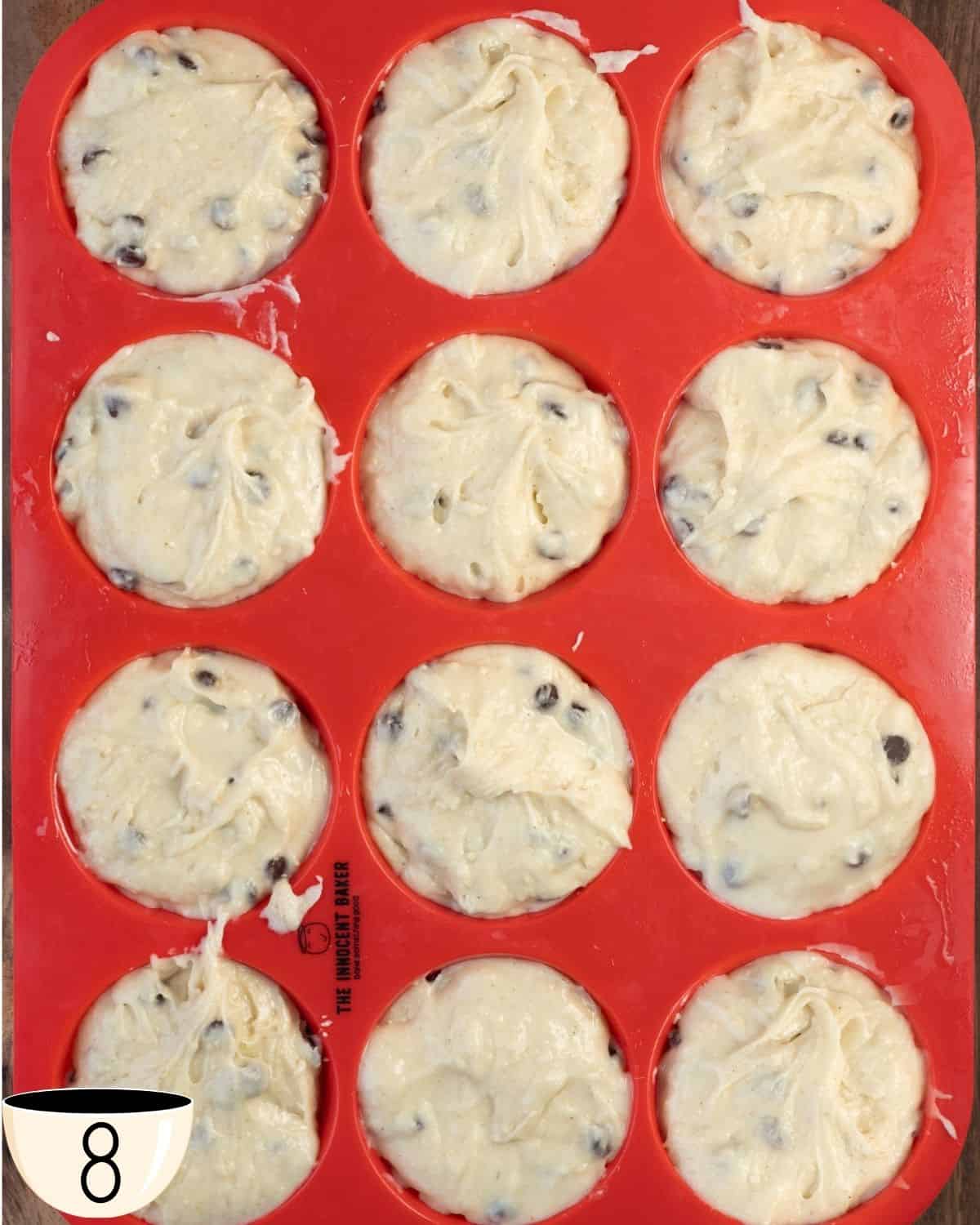 Gluten-free muffin batter portioned into a red silicone muffin tin, ready to be baked.