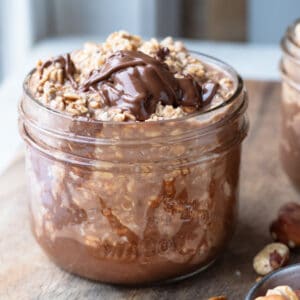 A jar of overnight oats, generously topped with Nutella chocolate.