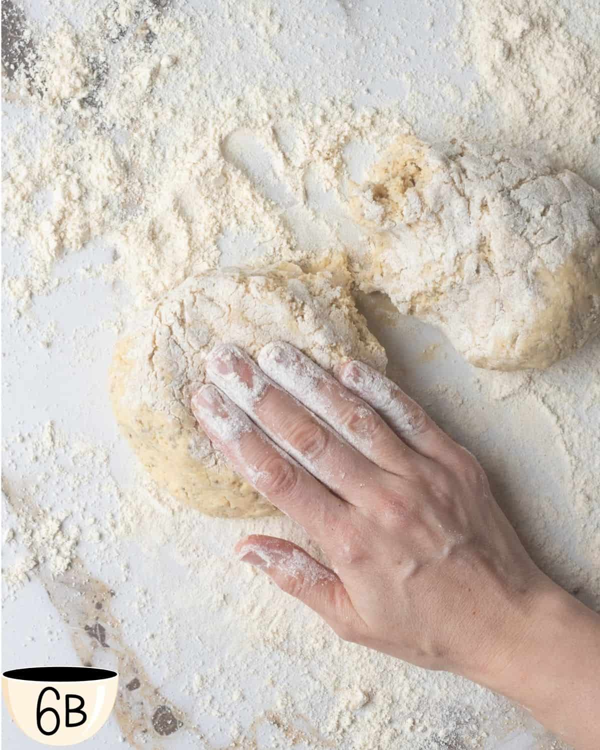 Hand shaping the gluten-free vegan bagel dough on a floured marble surface.