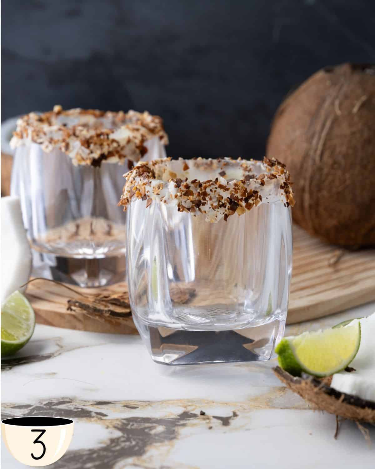 Two glass with a toasted coconut flakes rim ready for the coconut cream cocktail.
