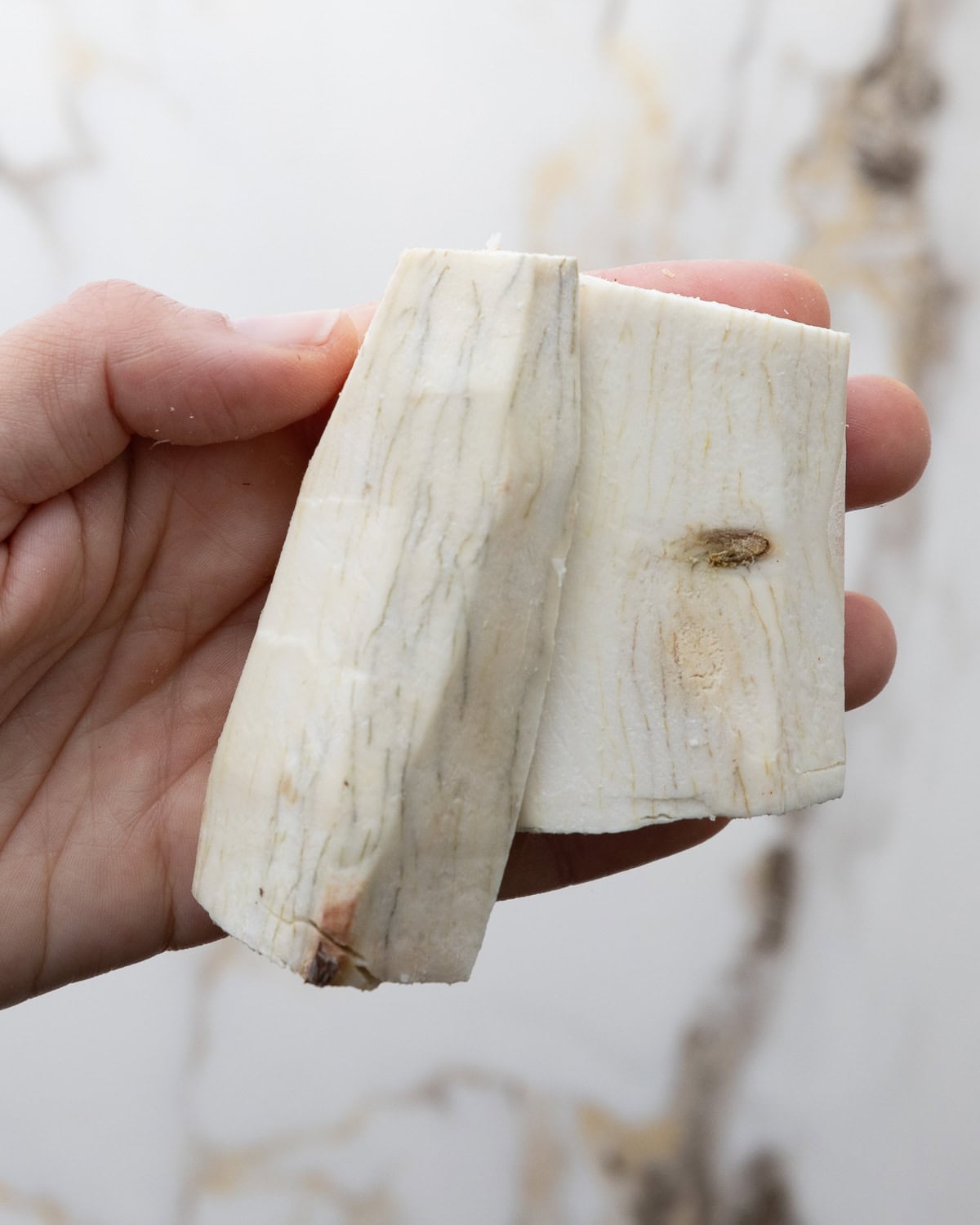 Close up of yuca root with black lines or veins to show when yuca should not be eaten.