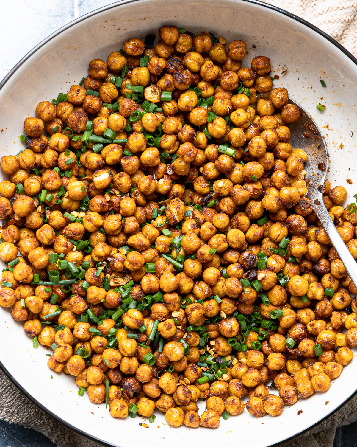 Crispy chili-lime chickpeas topped with chopped green onions in a serving bowl.