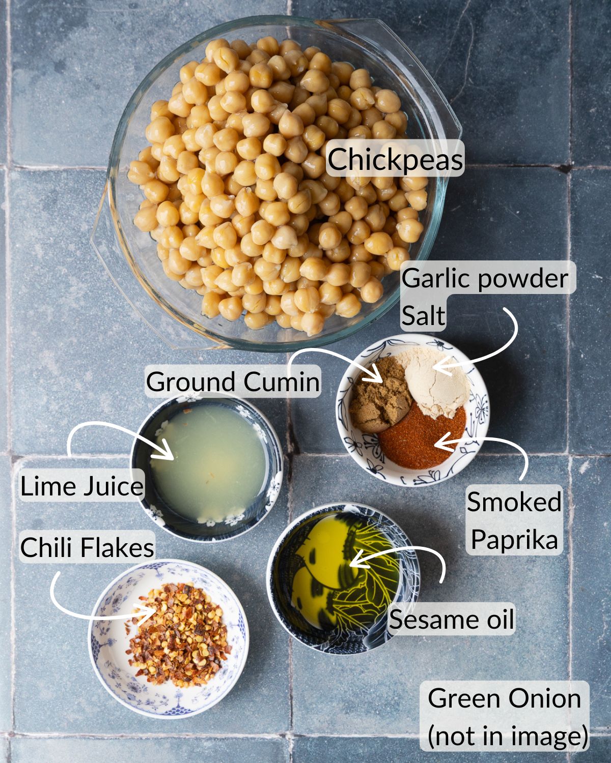 Ingredients for smoky chili-lime air fryer chickpeas, including chickpeas, ground cumin, garlic powder, chili flakes, lime juice, and sesame oil.