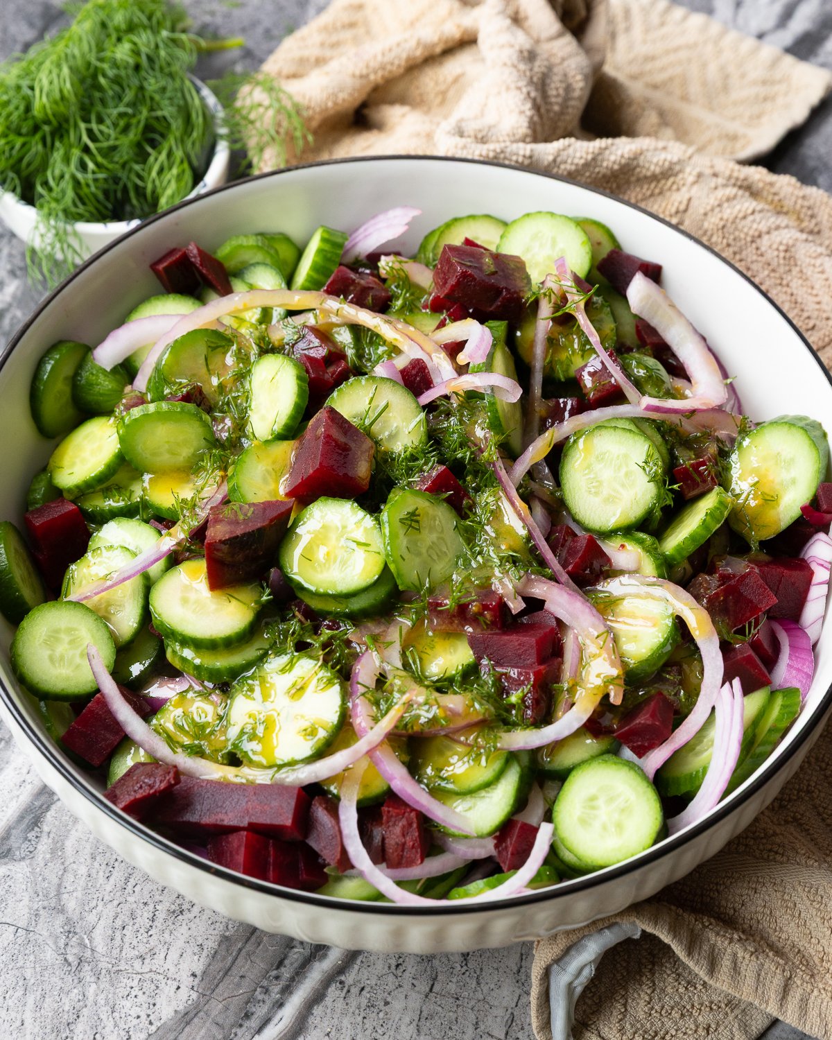 Cucumber beet salad tossed with red onion and dill, coated in citrusy mustard dressing.
