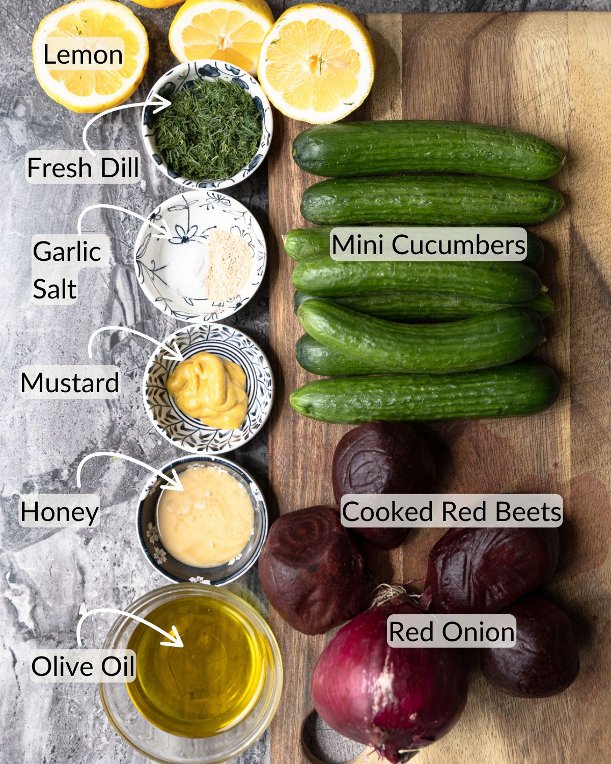 Labeled ingredients for cucumber beet salad laid out on a cutting board and counter before slicing or mixing.